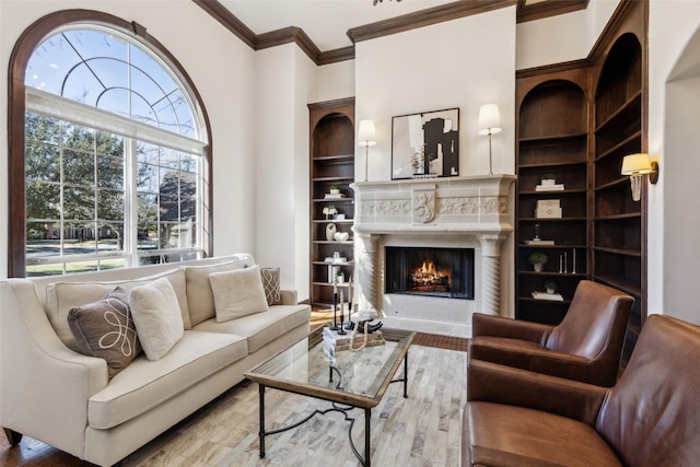 living room with ornamental molding, wood-type flooring, and a high end fireplace