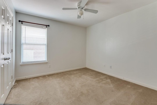 unfurnished room featuring light colored carpet and ceiling fan