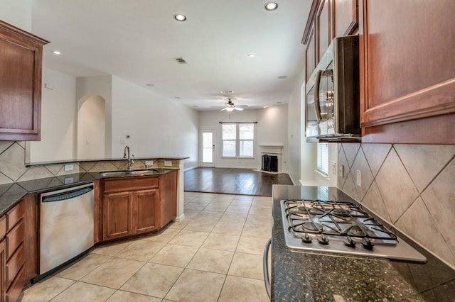 kitchen featuring sink, light tile patterned floors, ceiling fan, appliances with stainless steel finishes, and decorative backsplash