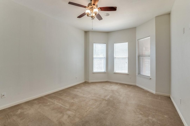 carpeted spare room featuring ceiling fan