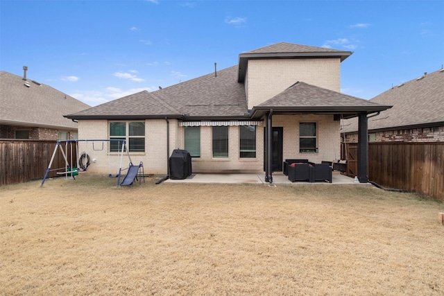 rear view of property with an outdoor living space, a patio, and a playground