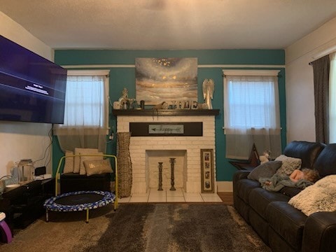 living room featuring light carpet and a brick fireplace