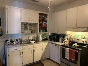 kitchen with dishwasher, sink, stainless steel electric range, and white cabinets