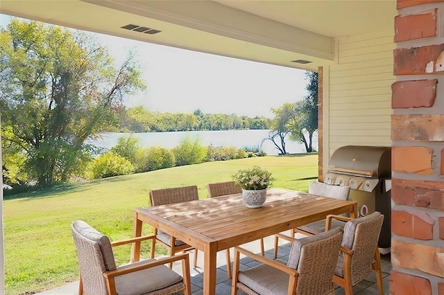 view of patio with a water view, visible vents, area for grilling, and outdoor dining space