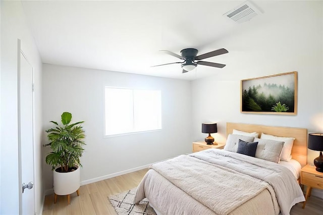 bedroom with baseboards, visible vents, ceiling fan, and wood finished floors