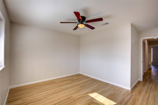 empty room with light wood-style floors, baseboards, visible vents, and ceiling fan