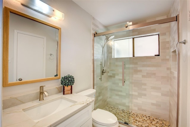 full bath featuring a stall shower, vanity, and toilet