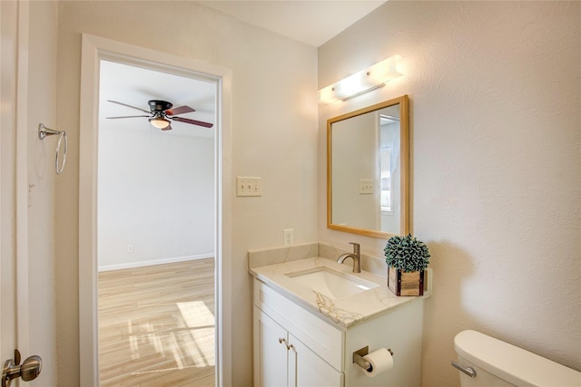 bathroom featuring vanity, hardwood / wood-style floors, ceiling fan, and toilet