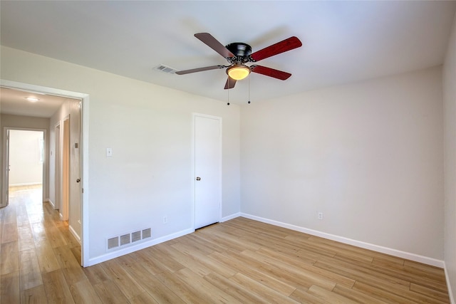 unfurnished room featuring a ceiling fan, light wood-type flooring, visible vents, and baseboards