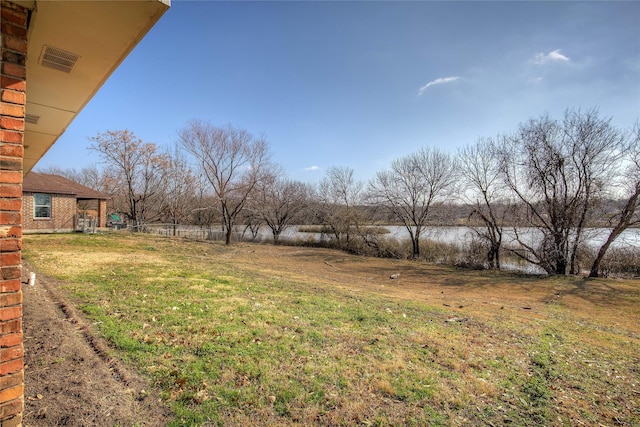 view of yard featuring a water view and visible vents