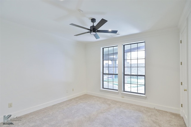 carpeted empty room with ceiling fan, plenty of natural light, and ornamental molding