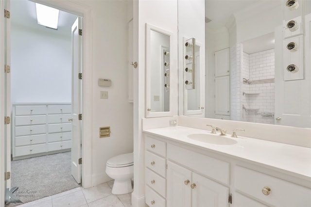 bathroom with tile patterned flooring, vanity, toilet, and walk in shower