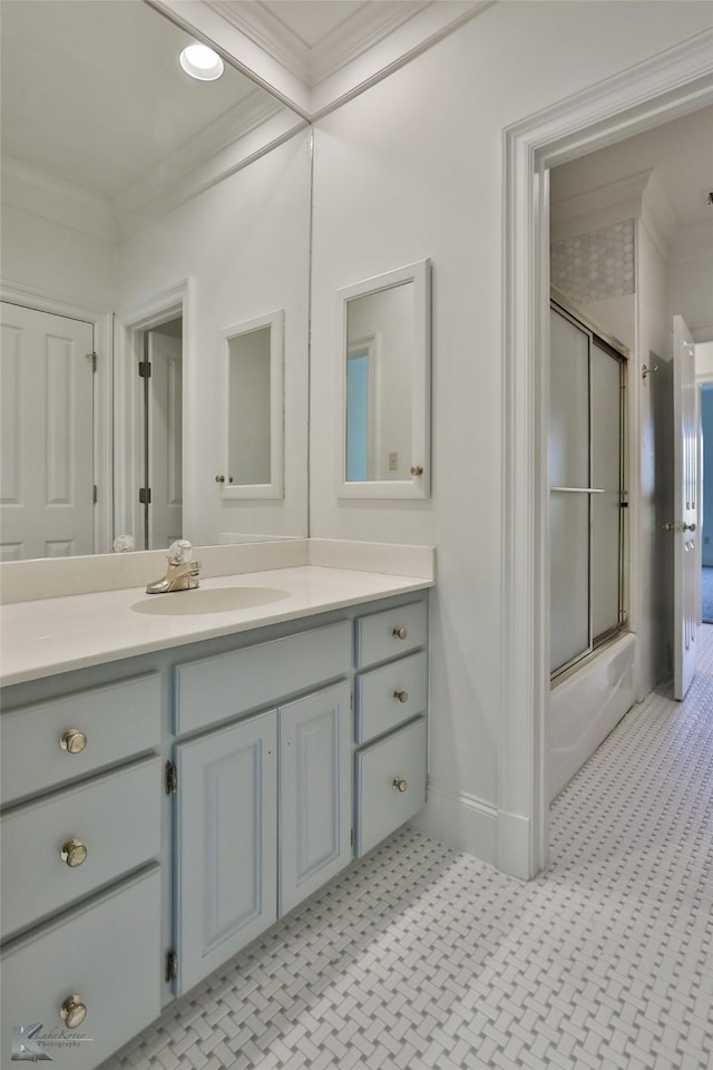 bathroom with vanity, ornamental molding, and enclosed tub / shower combo