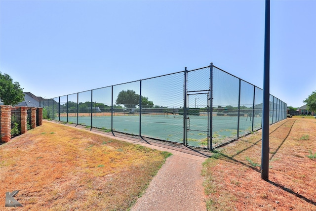 view of tennis court with a yard