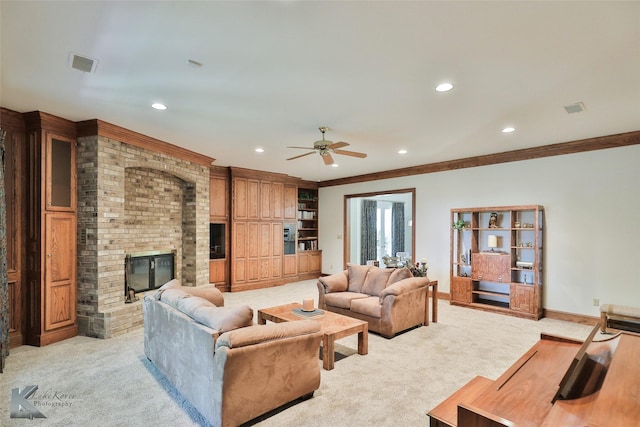 living room with ceiling fan, light colored carpet, ornamental molding, and a brick fireplace