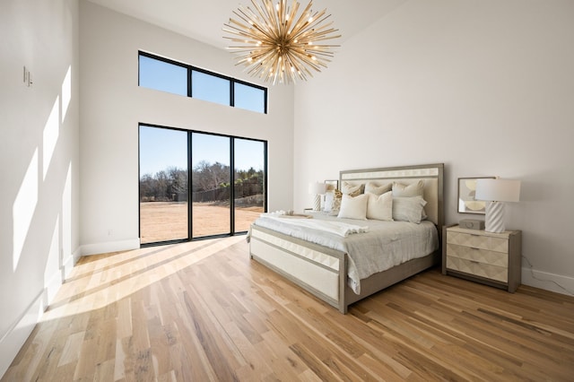 bedroom featuring multiple windows, hardwood / wood-style floors, and a notable chandelier