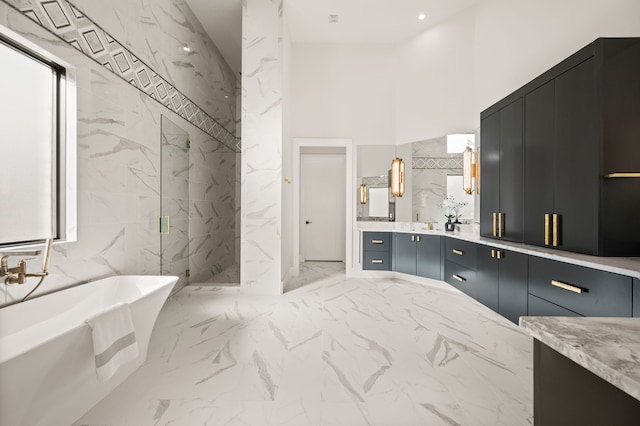 bathroom with vanity, independent shower and bath, and a high ceiling