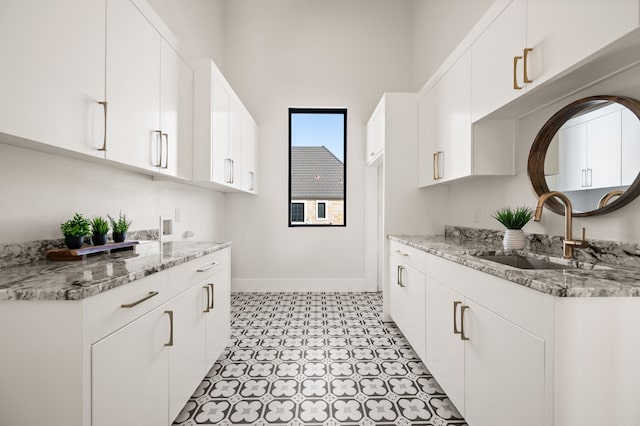 kitchen featuring white cabinetry and sink