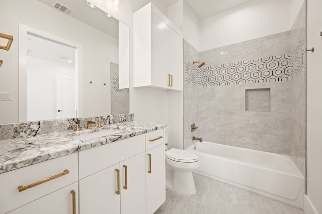 full bathroom featuring tiled shower / bath, vanity, and toilet