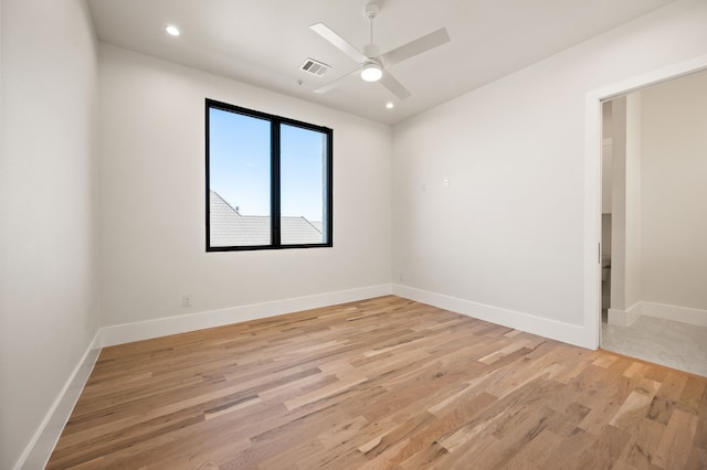 empty room with ceiling fan and light hardwood / wood-style floors