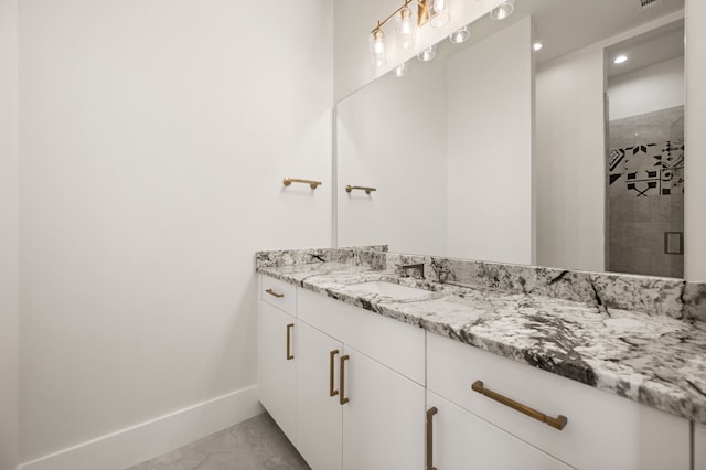 bathroom featuring a shower with door and vanity