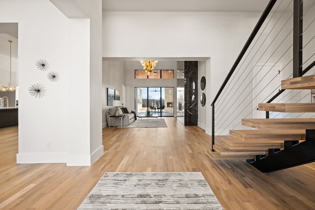 entryway with sink, hardwood / wood-style floors, and a notable chandelier