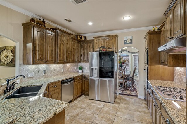 597 Imagine Dr, Lindale, TX 75771 - kitchen featuring sink, crown molding, stainless steel appliances, light stone countertops, and decorative backsplash