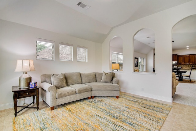 living room with light tile patterned floors and vaulted ceiling