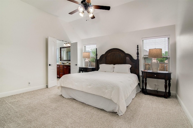 carpeted bedroom with connected bathroom, vaulted ceiling, and ceiling fan