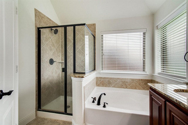 bathroom featuring a healthy amount of sunlight, vanity, independent shower and bath, and vaulted ceiling