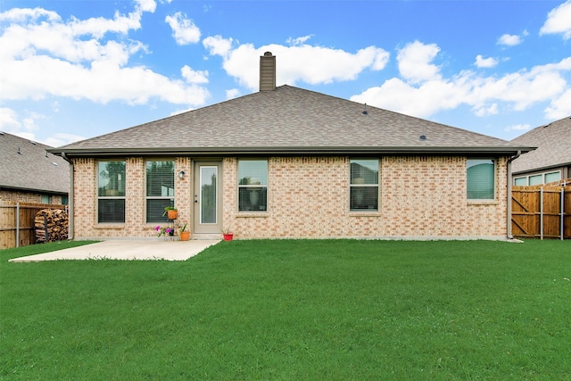 rear view of property featuring a yard and a patio area