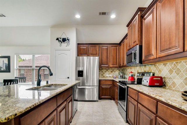 kitchen featuring sink, light tile patterned floors, appliances with stainless steel finishes, tasteful backsplash, and light stone countertops