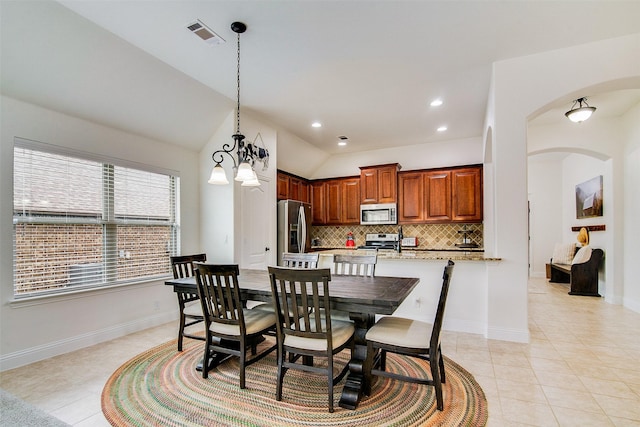 dining room with light tile patterned flooring and vaulted ceiling