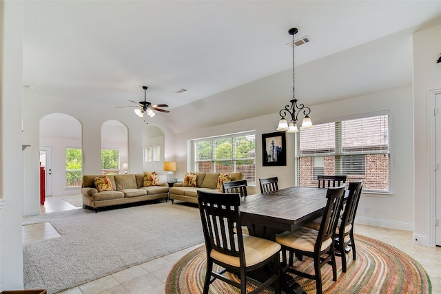 tiled dining space featuring high vaulted ceiling and ceiling fan with notable chandelier