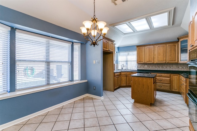 kitchen featuring pendant lighting, light tile patterned floors, vaulted ceiling, and a center island