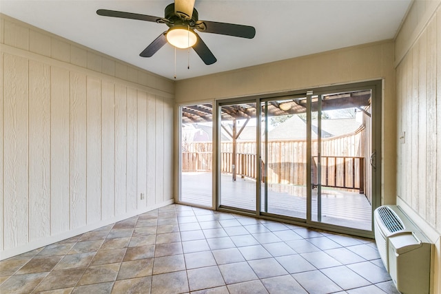 tiled empty room with ceiling fan, wood walls, and an AC wall unit