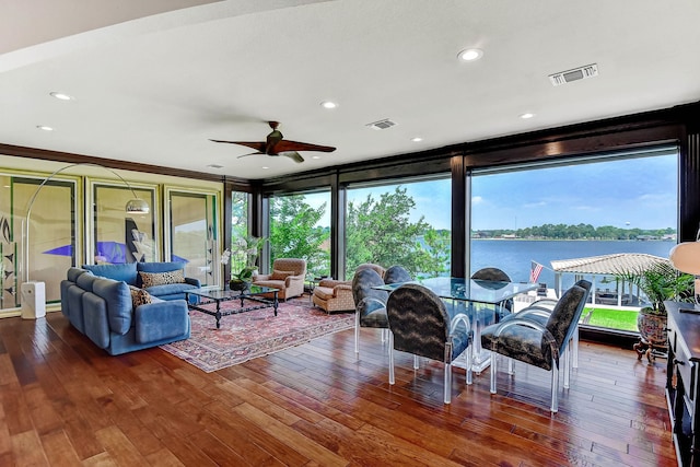 living room with a water view, ceiling fan, and wood-type flooring