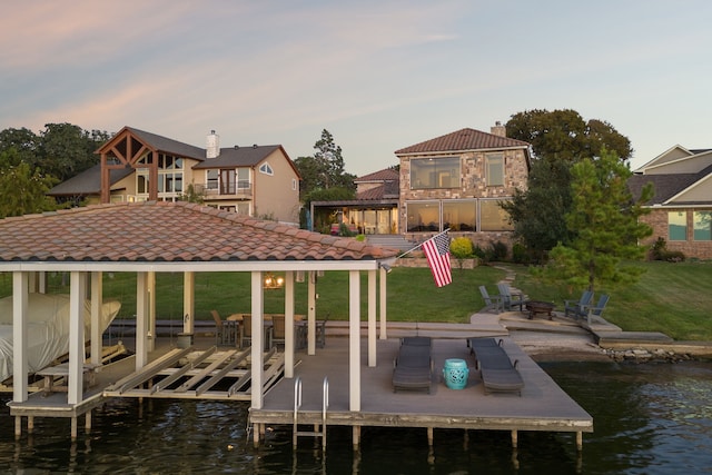 dock area with a gazebo, a water view, a lawn, and an outdoor fire pit