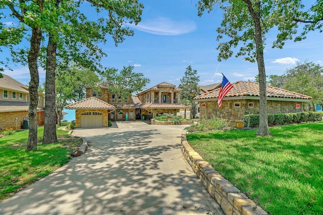 mediterranean / spanish home with a garage and a front lawn