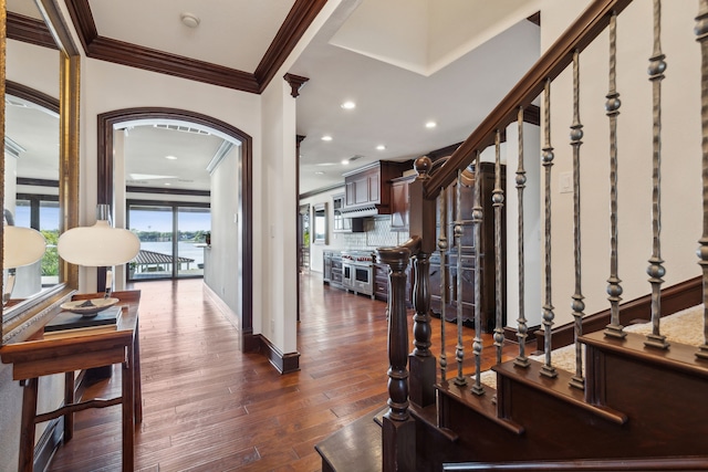 interior space with decorative columns, ornamental molding, and dark wood-type flooring