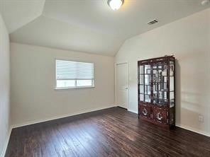 empty room with lofted ceiling and dark hardwood / wood-style flooring