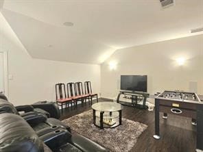 home theater room featuring lofted ceiling and dark hardwood / wood-style floors