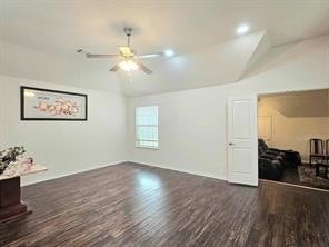 living room featuring vaulted ceiling, dark hardwood / wood-style floors, and ceiling fan