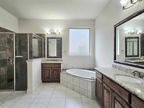 bathroom featuring independent shower and bath, vanity, and tile patterned floors