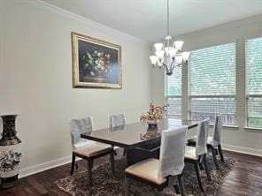 dining room featuring dark wood-type flooring, crown molding, and a chandelier