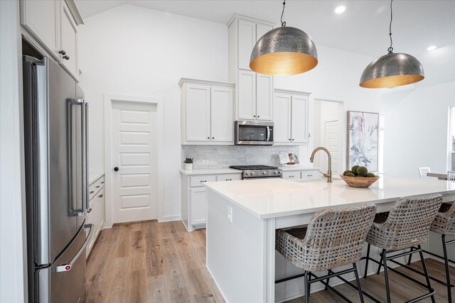 3512 Pritchard Rd, Celina, TX 75009 - kitchen with appliances with stainless steel finishes, a sink, a breakfast bar area, light countertops, and high vaulted ceiling