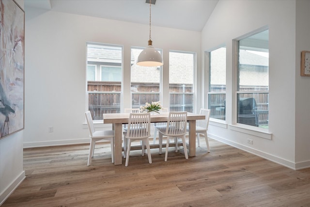 dining area with lofted ceiling and hardwood / wood-style flooring