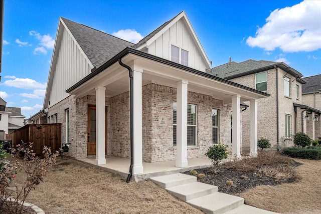 3512 Pritchard Rd, Celina, TX 75009 - view of front facade with board and batten siding, a porch, brick siding, and roof with shingles