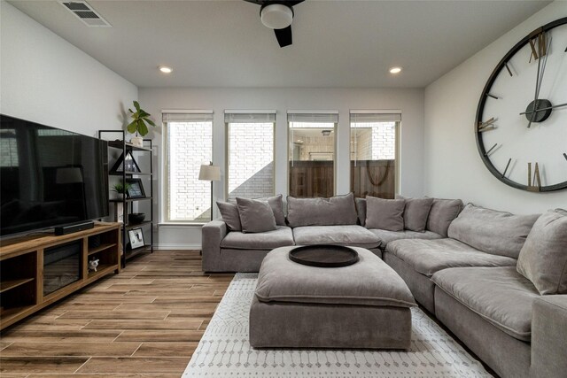 living room with wood-type flooring and ceiling fan