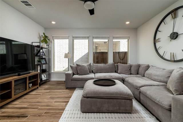 living room featuring baseboards, visible vents, ceiling fan, wood finished floors, and recessed lighting